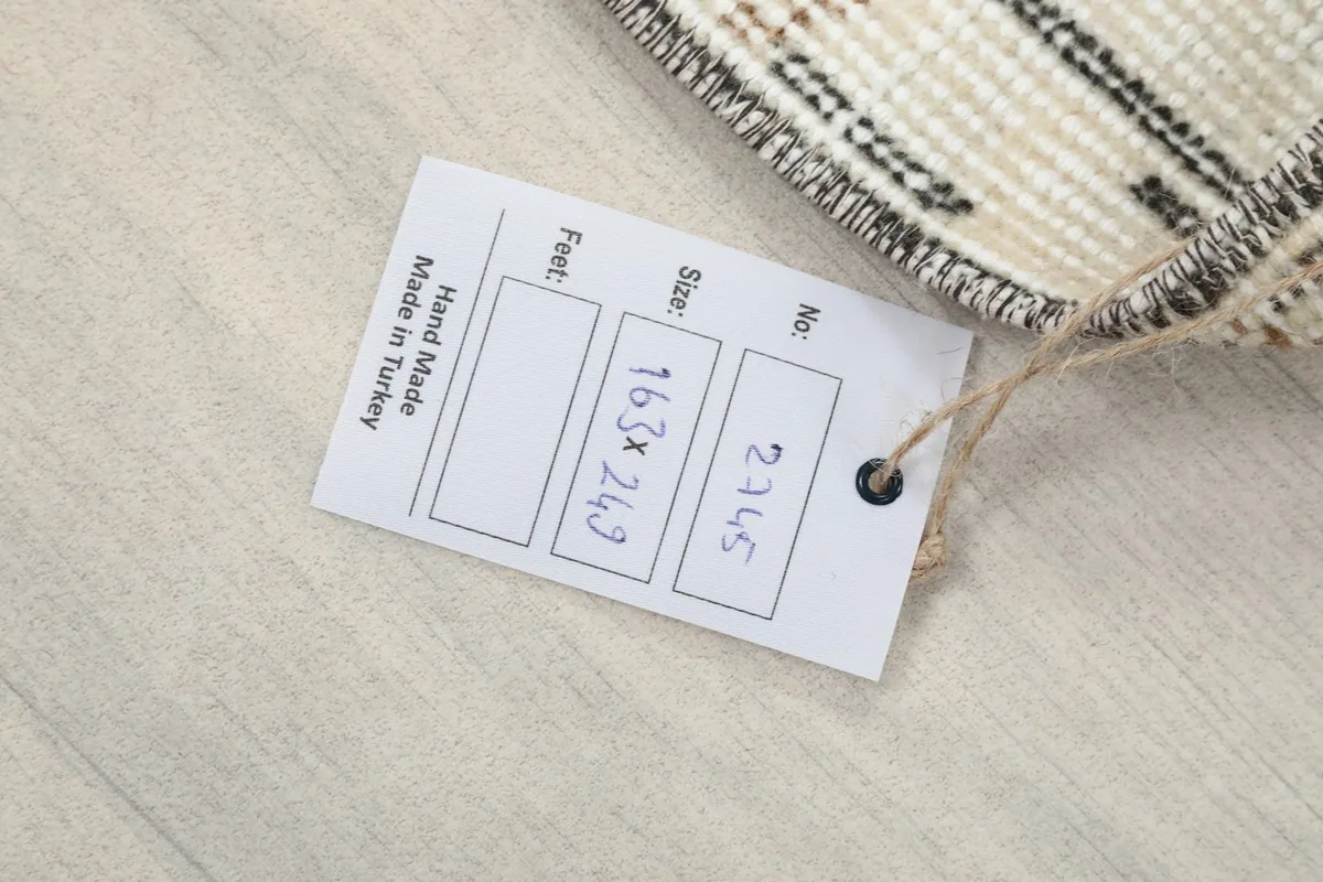 Product tag displaying the rug's dimensions in centimeters and 'Hand Made in Turkey'