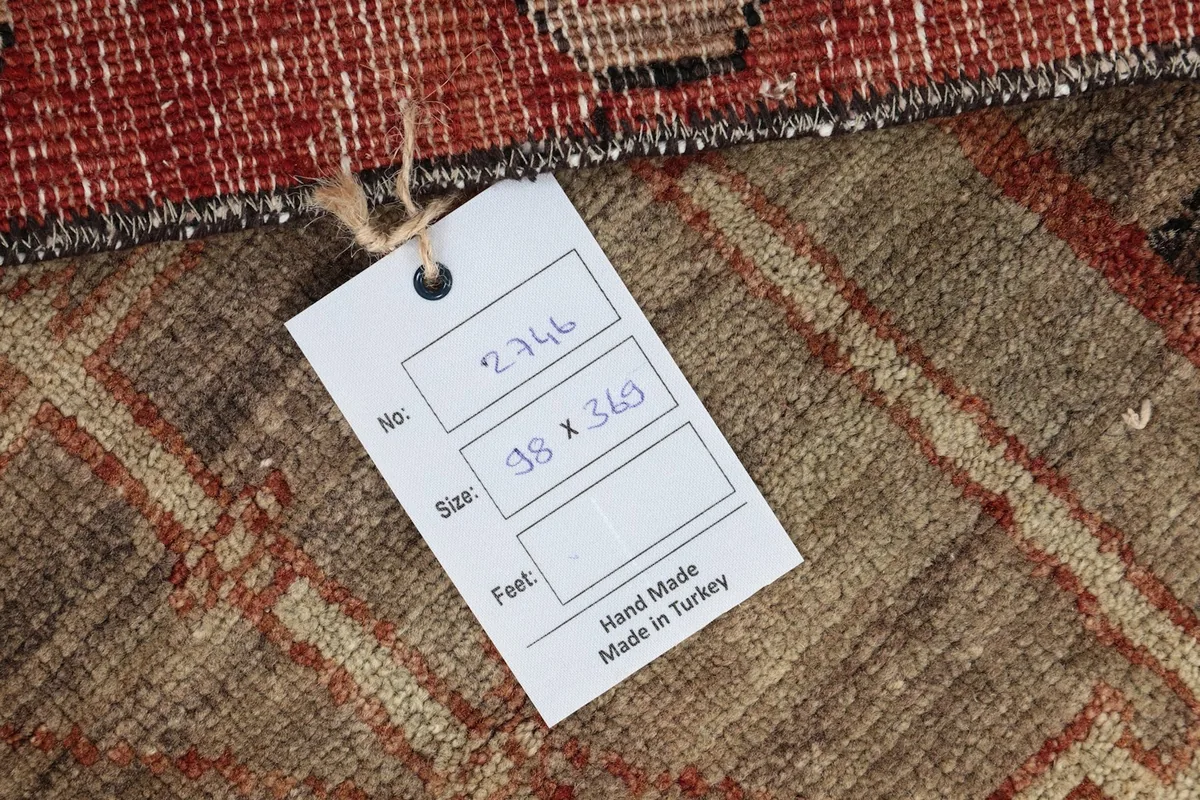 Back of the rug with a tag showing the dimensions and handmade origin