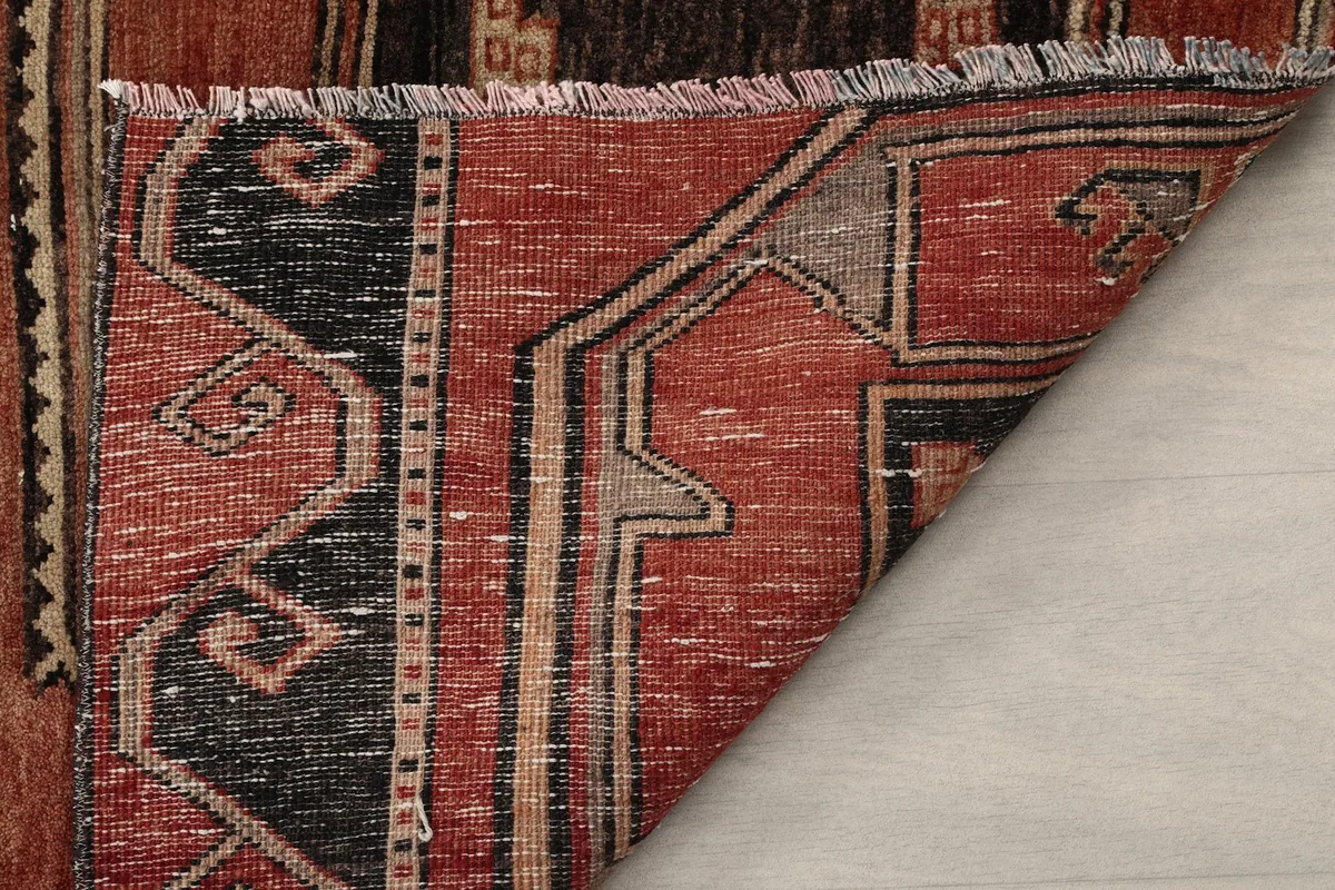Another view of the folded rug corner, highlighting the texture and wear