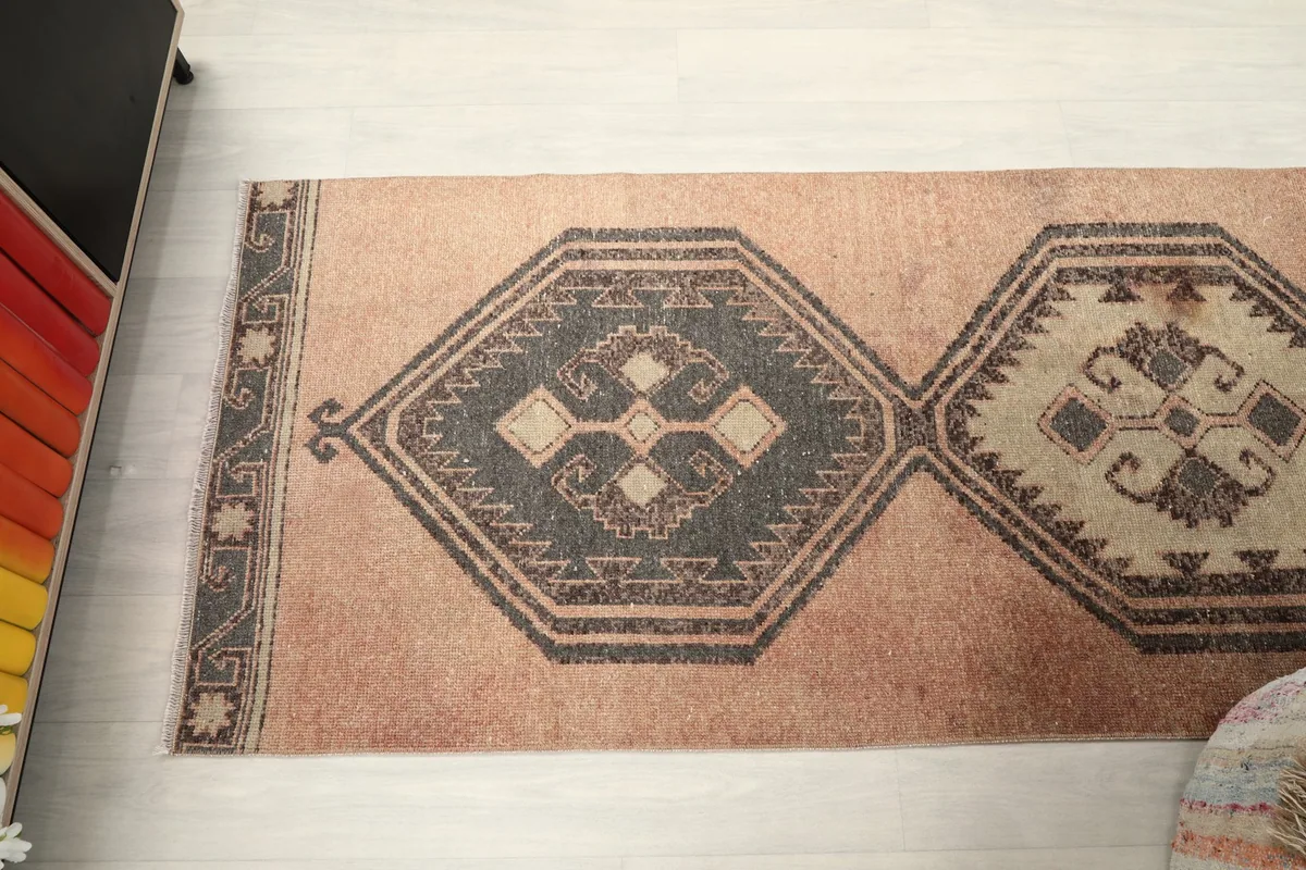 Angled top-down view highlighting the repeating geometric medallions of the runner rug.