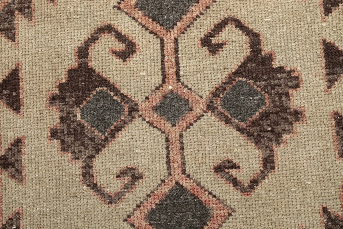 Detailed view of the intricate tribal pattern within a beige medallion on the runner.