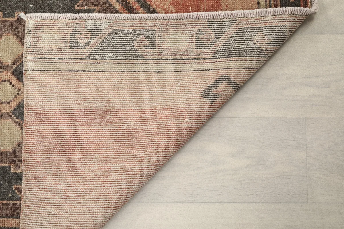 Underside of the runner rug, showing the reverse side of the wool pile and cotton foundation.
