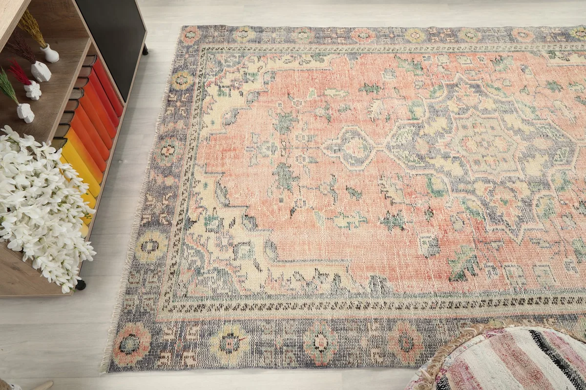 Wide angle shot of the rug's design and colors, with part of the room decor visible.