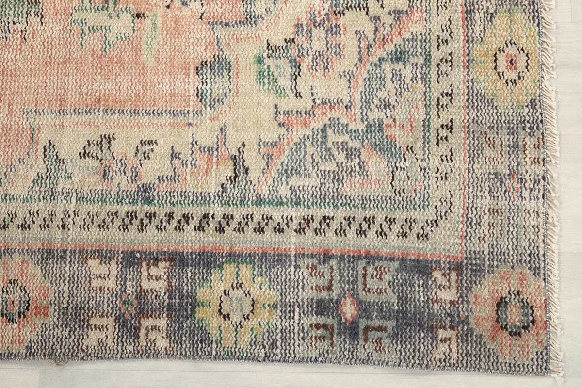 Detail of the gray border pattern and corner of the rose field, showing subtle green and yellow accents.