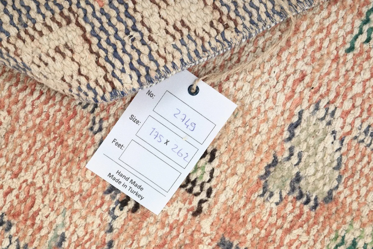Close-up of the care tag on the back of the rug, showing size in centimeters and origin.