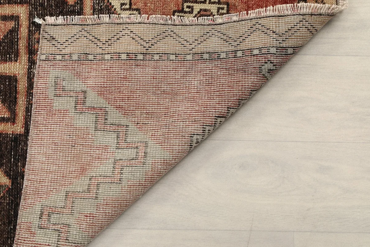 Close-up of the back of the rug, showing the reverse side of the hand-knotted weave and fringe