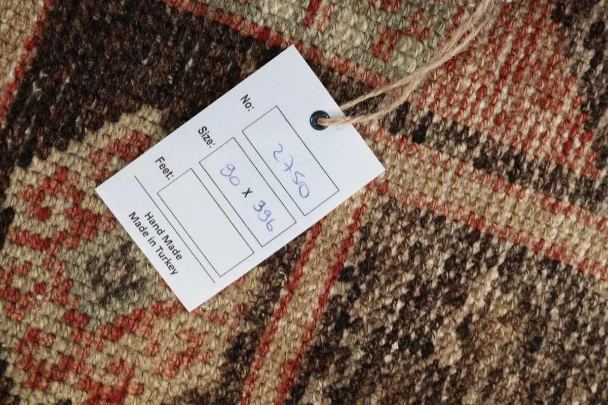 Product tag attached to the rug, displaying size information in centimeters and feet for reference
