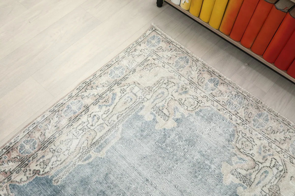 Top-down angle showcasing the upper portion of the blue and ivory vintage rug