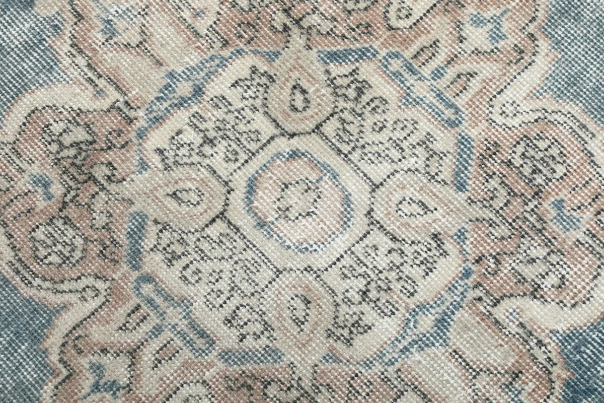 Detailed view of the hand-knotted patterns within the rug's central medallion
