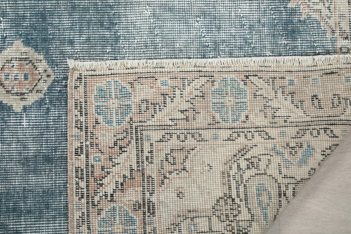 Close-up of the rug's reverse side, showing the knotting and fringe detail