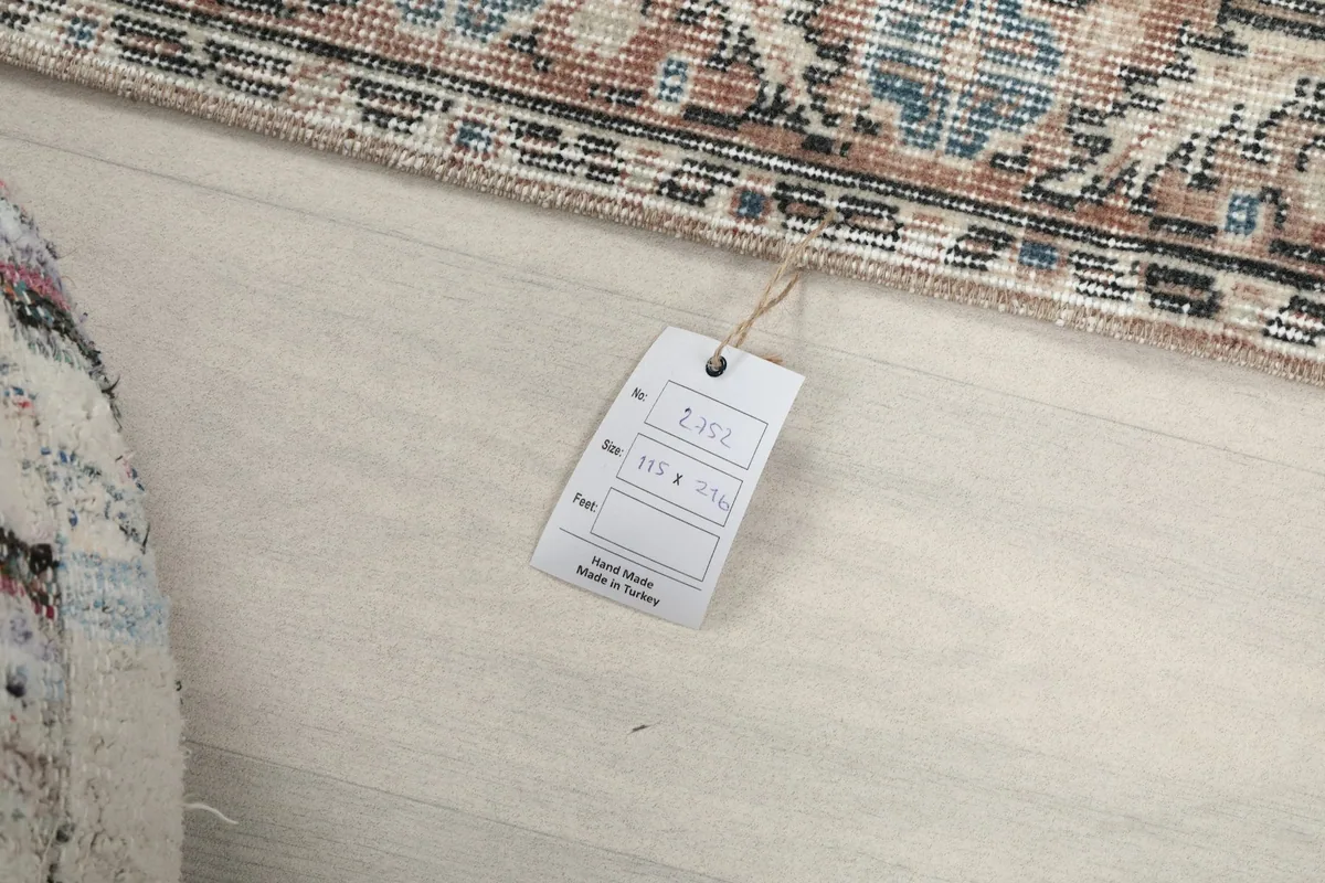 Close-up of the product tag attached to the vintage hand-knotted rug