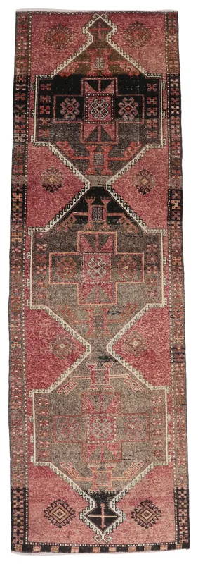 Full overhead view of the rose and brown tribal Anatolian runner rug on a white background