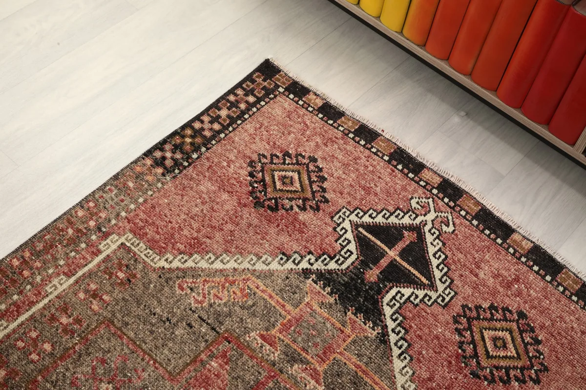 Close-up of the rug's corner, highlighting the distinct border patterns and fringe