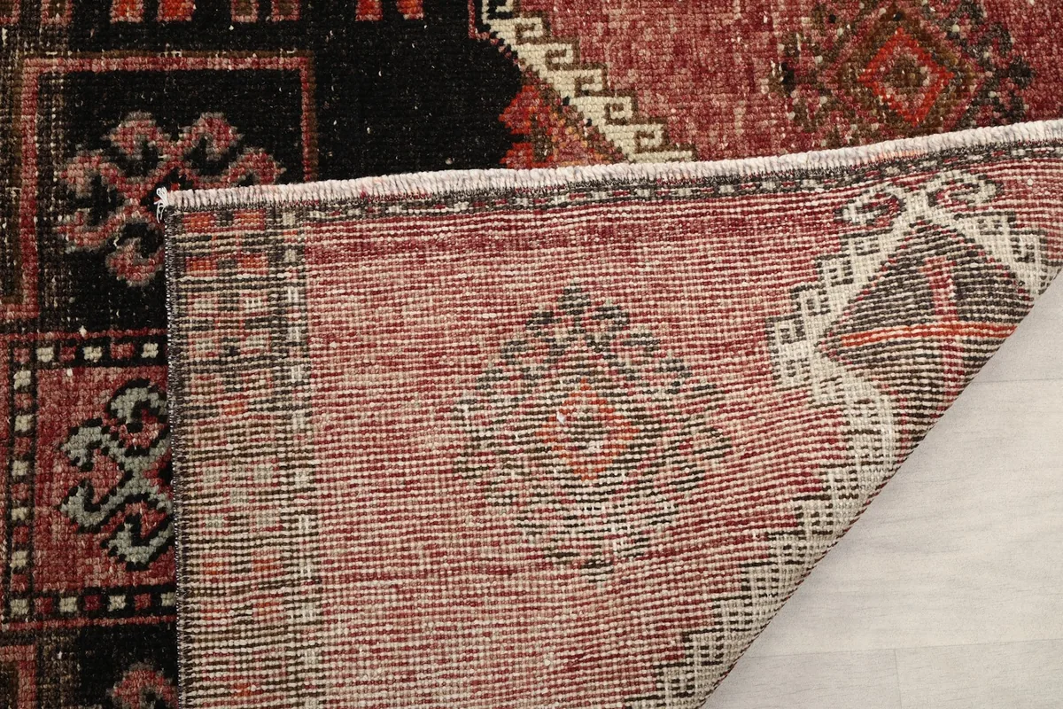 Another view of the rug's underside, showing the tightly woven cotton foundation and knotting