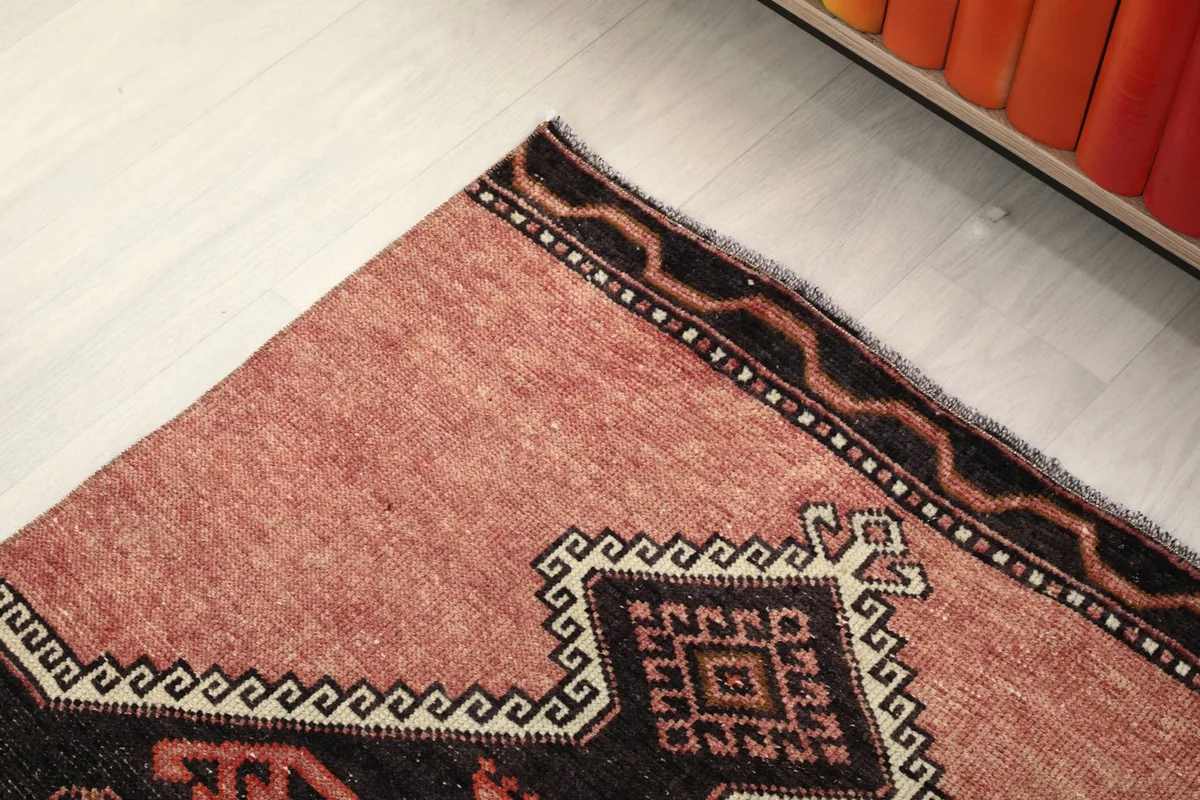 Close-up of the rug's border and corner, highlighting the simple black edge