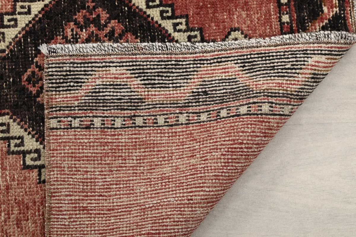 Underside of the rug, displaying the hand-knotted construction and fringe details