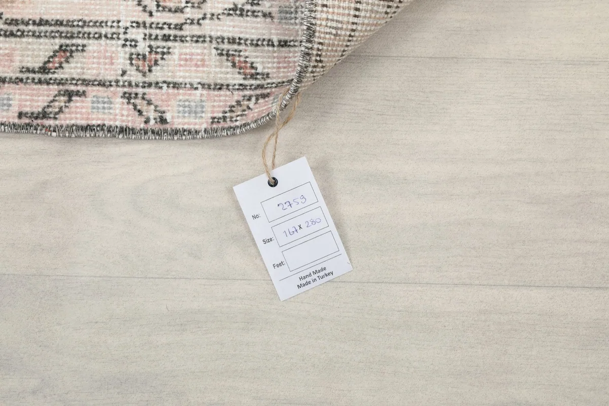 Tag displaying the rug's dimensions and origin, confirming it is a hand-knotted piece made in Turkey.