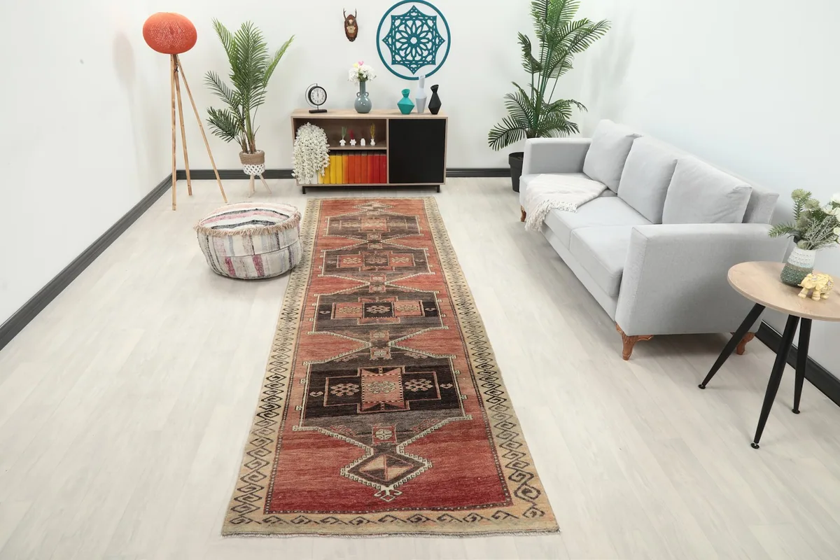 Vintage rust runner rug displayed in a modern hallway setting with a light grey couch