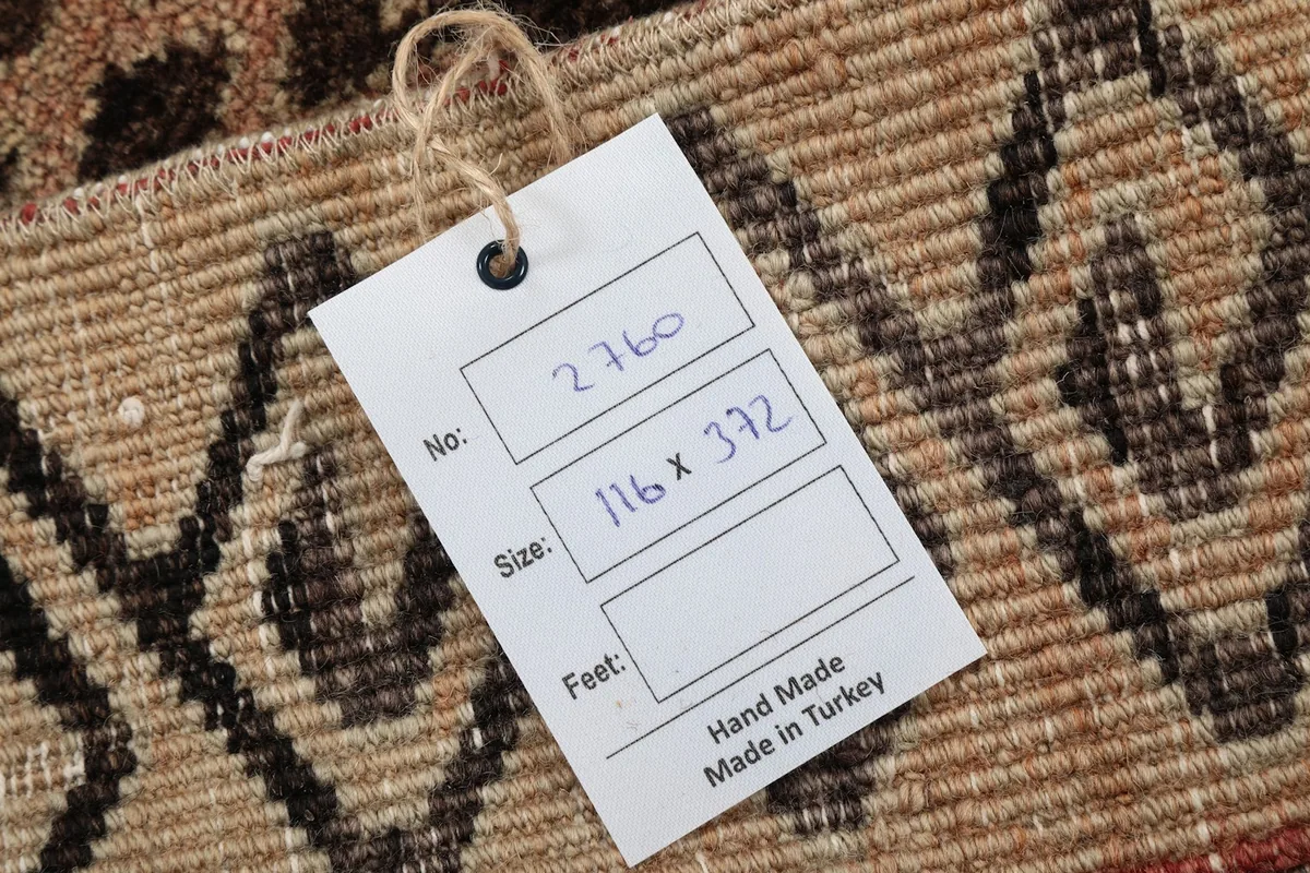 Tag showing the rug's dimensions in centimeters and confirming it is hand-made in Turkey