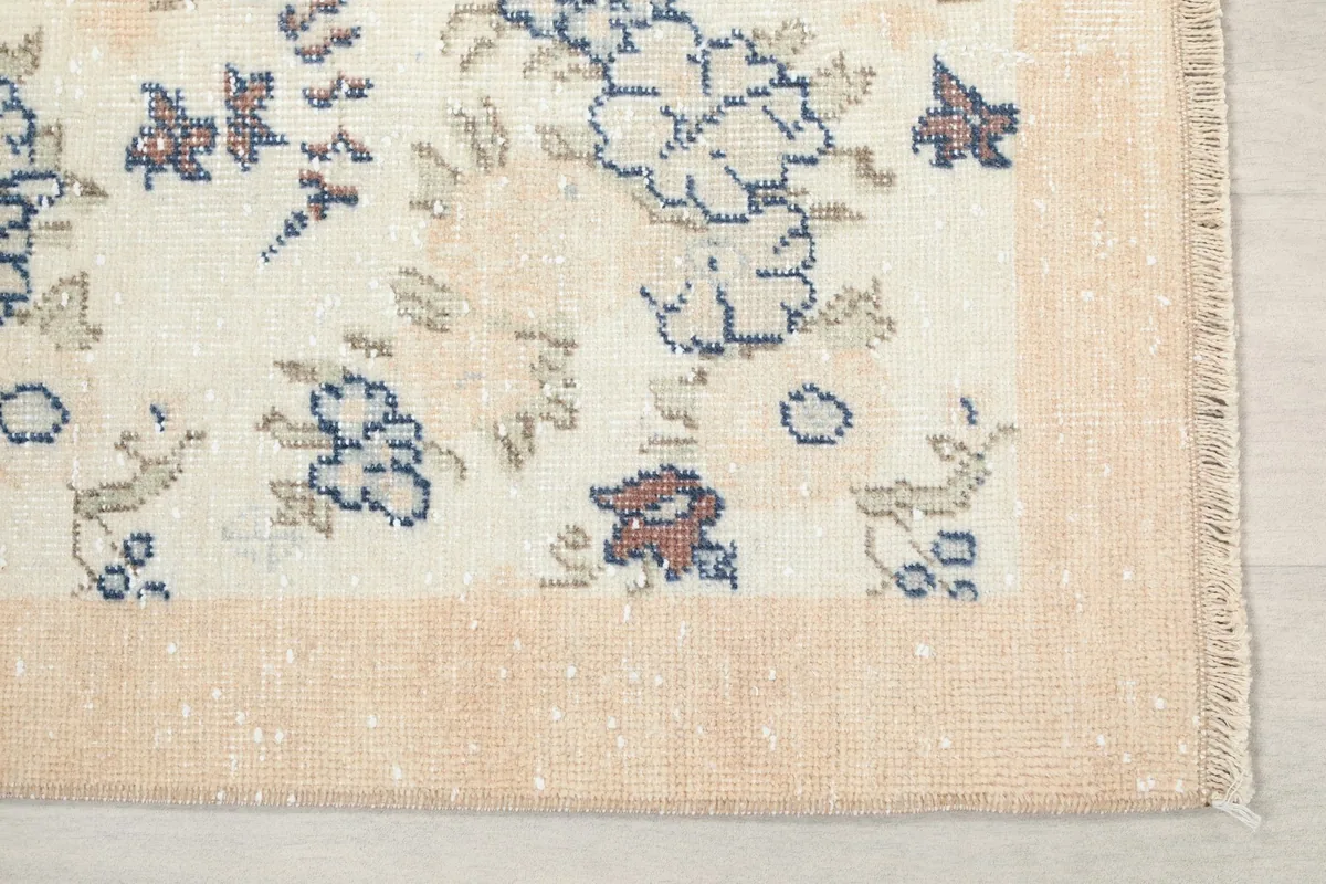 Close-up of the rug's tan border and the corner with fringe details