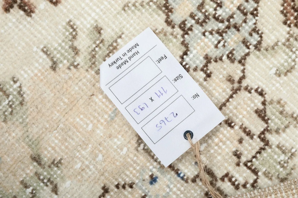 Close-up of the rug's label, indicating its handmade origin and dimensions