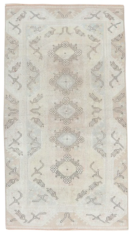 Full overhead view of the beige tribal diamond vintage Anatolian rug on a white background.
