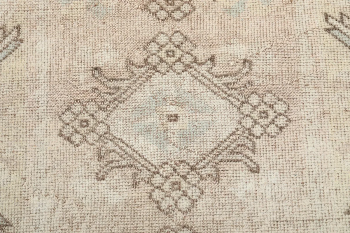 Close-up of a central diamond motif with intricate tan and charcoal geometric details.