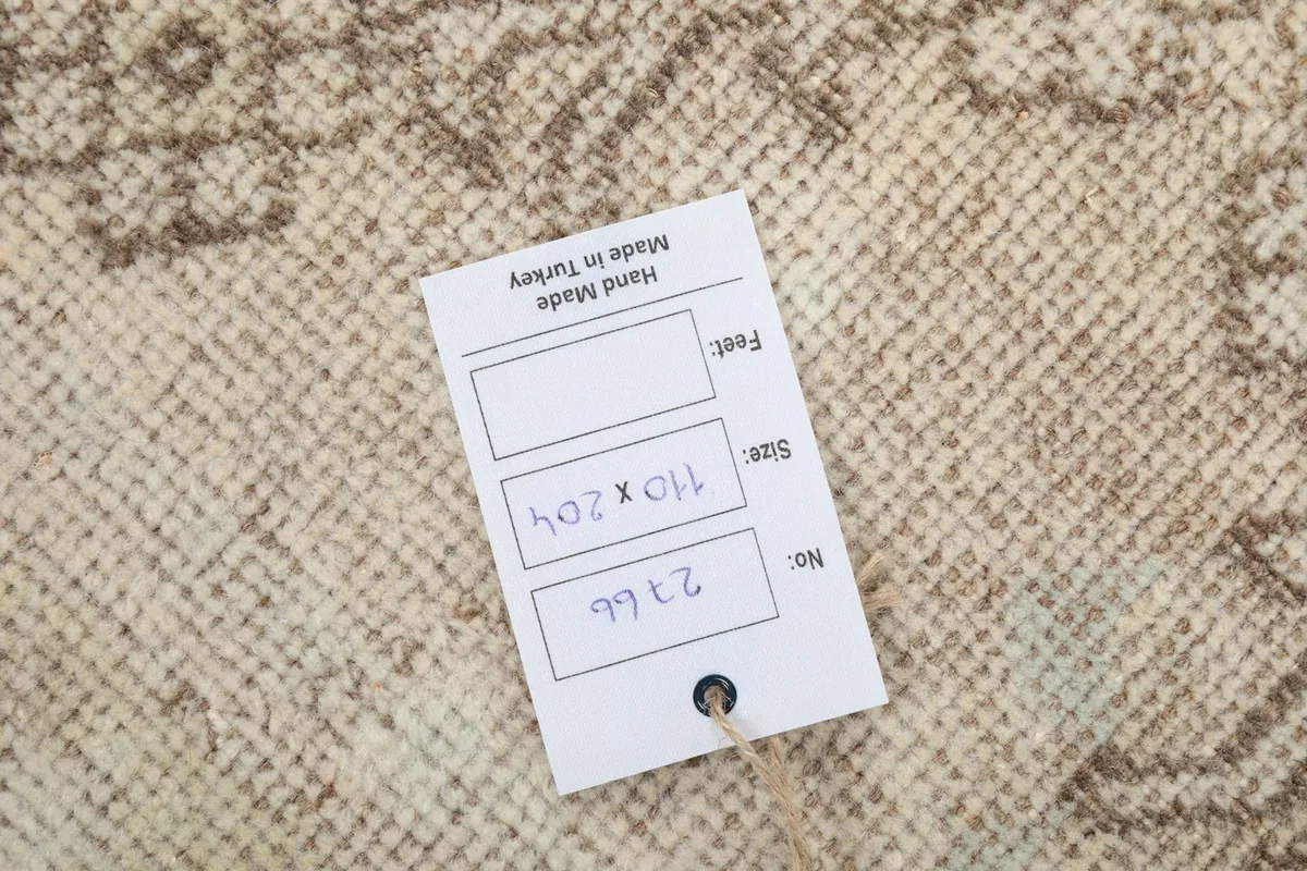Close-up of the product tag attached to the rug, showing its origin and dimensions.