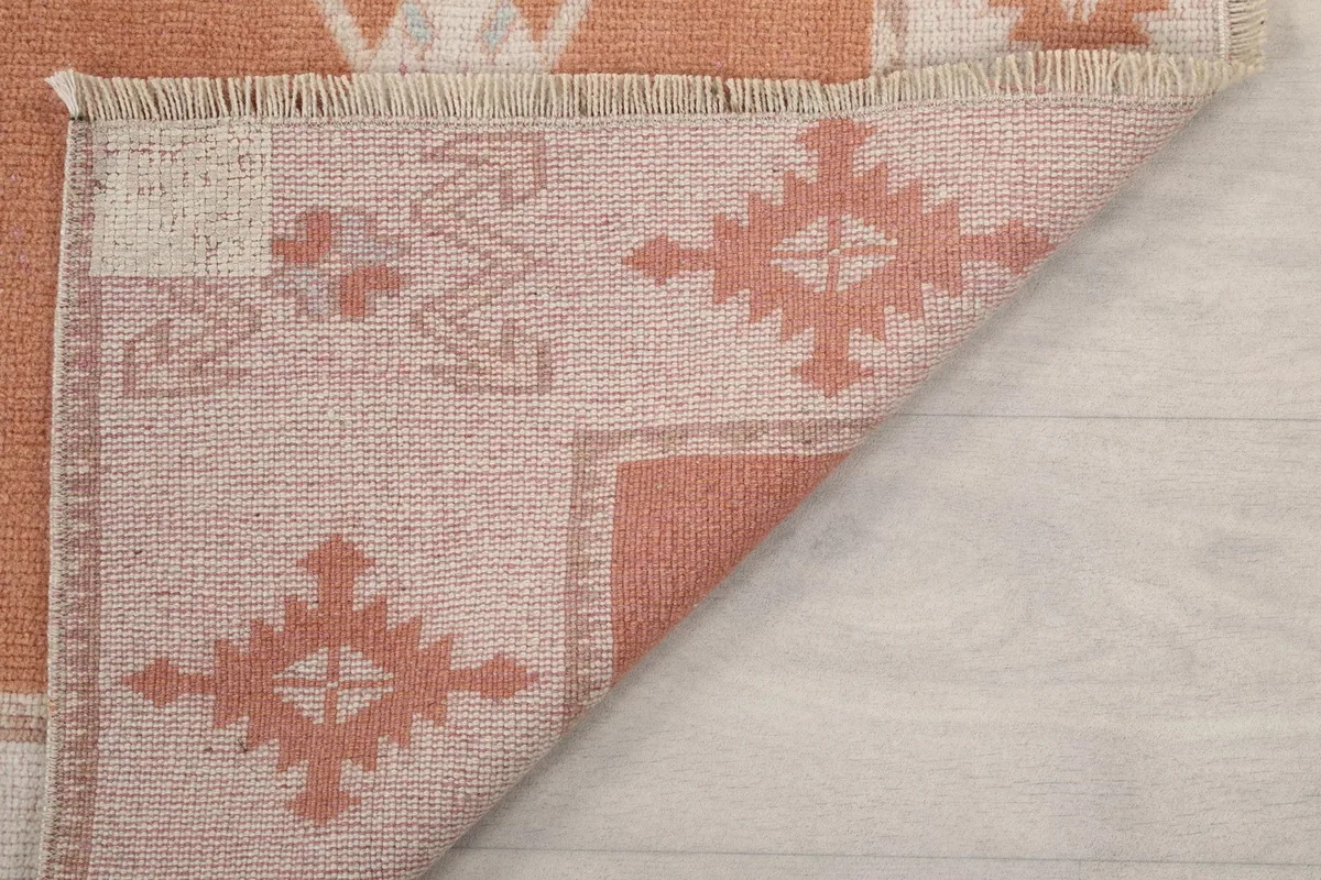 Detailed view of the reverse side of the rug, showing the knotting and the cotton foundation material.