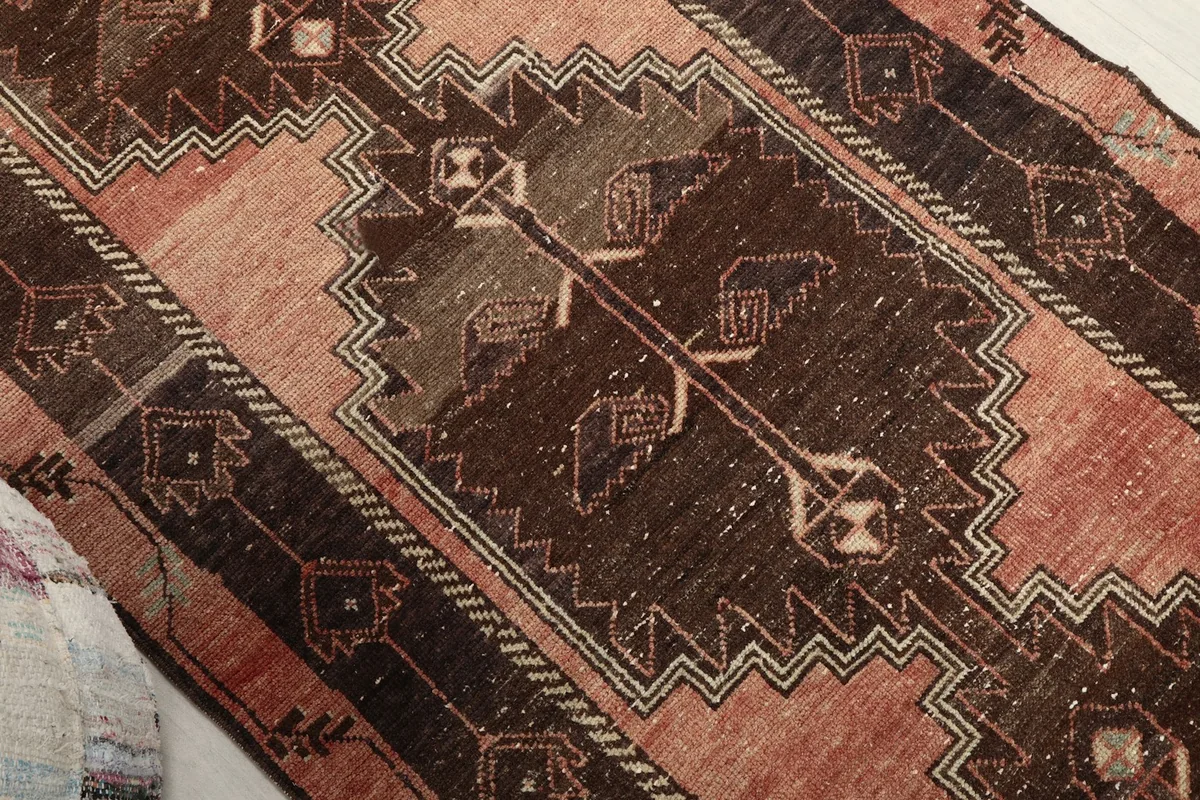 Close-up of a tribal motif within the brown central panel of the runner