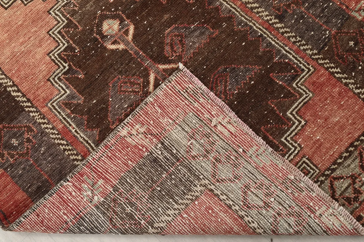 Folded corner showing the back of the hand-knotted wool rug on a cotton foundation