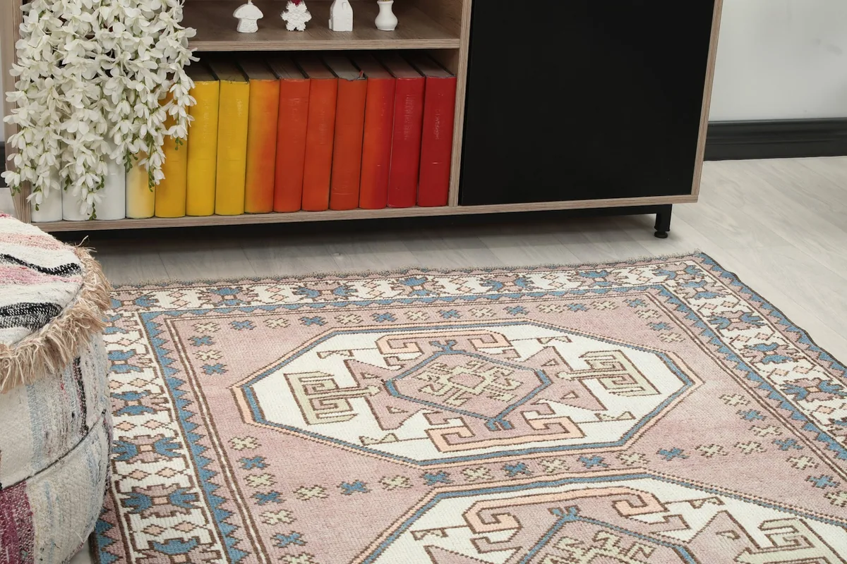 Close-up of the rug's center medallion and surrounding rose field in a room
