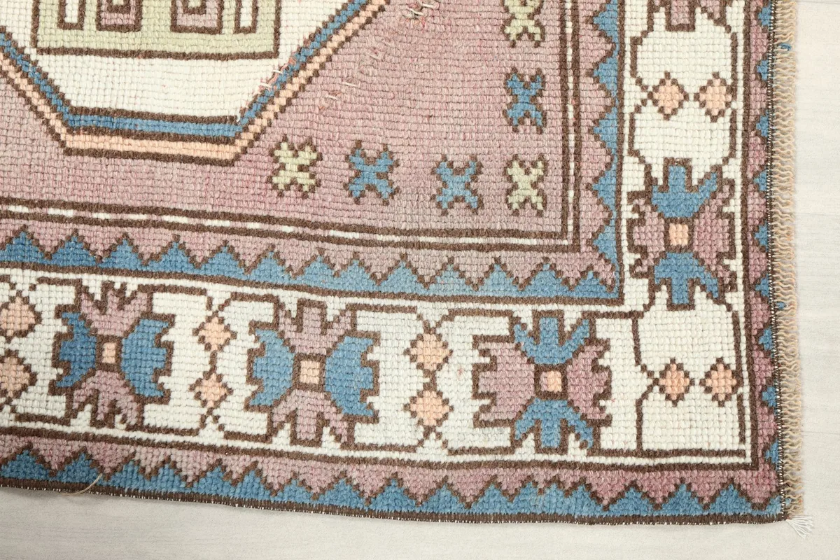 Detail of the blue and ivory geometric border pattern on the vintage rug