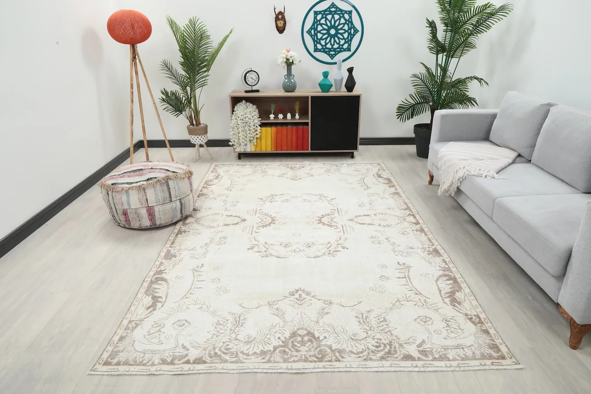 Ivory beige vintage rug in a living room setting with a light gray sofa