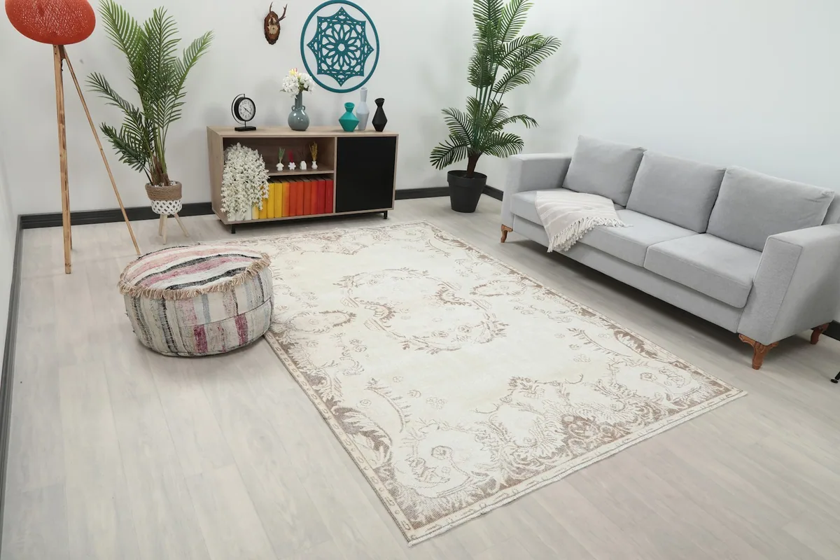 Angle view of the ivory beige vintage rug in a living room with a neutral decor