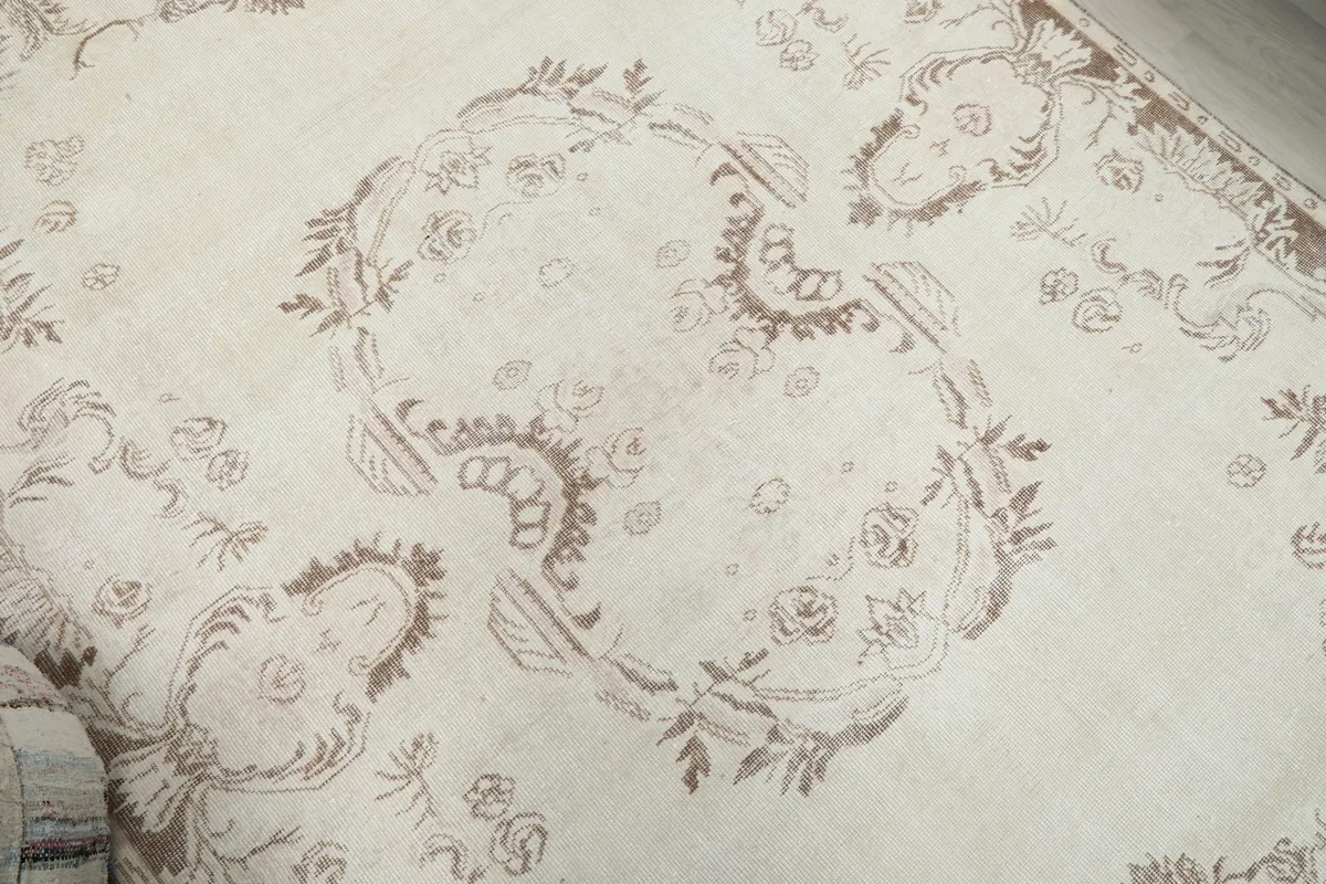 Close-up of the central ornamental motifs and faded colors on the rug