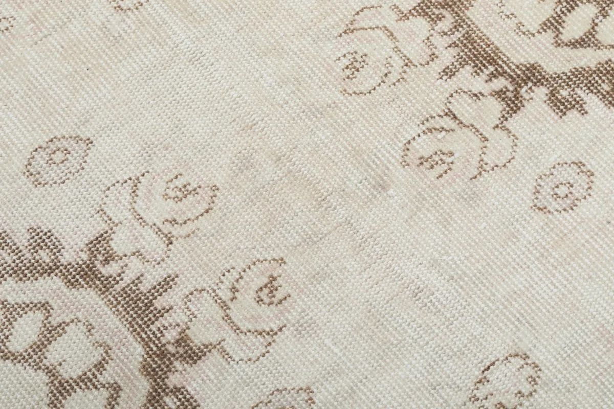 Texture and low pile of the hand-knotted wool rug, showing subtle wear