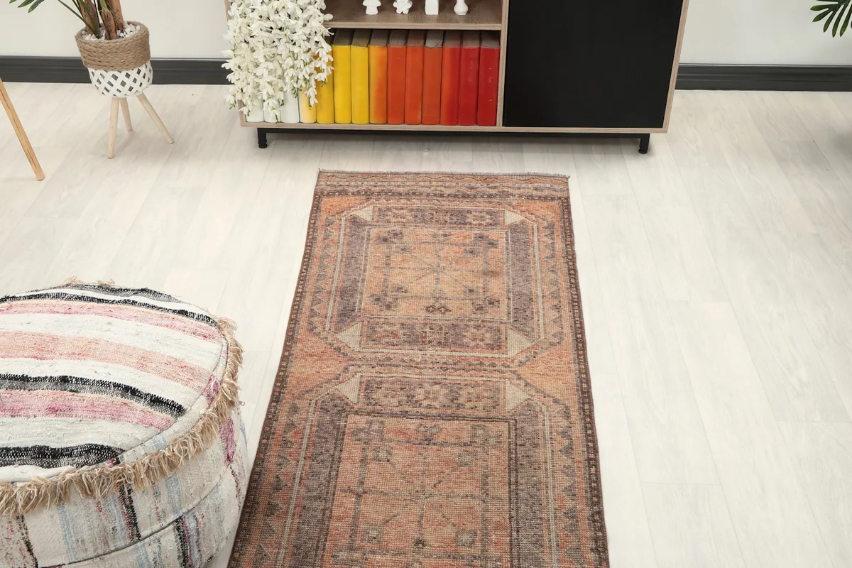 Overhead view of a section of the rust runner rug in a room, highlighting its length