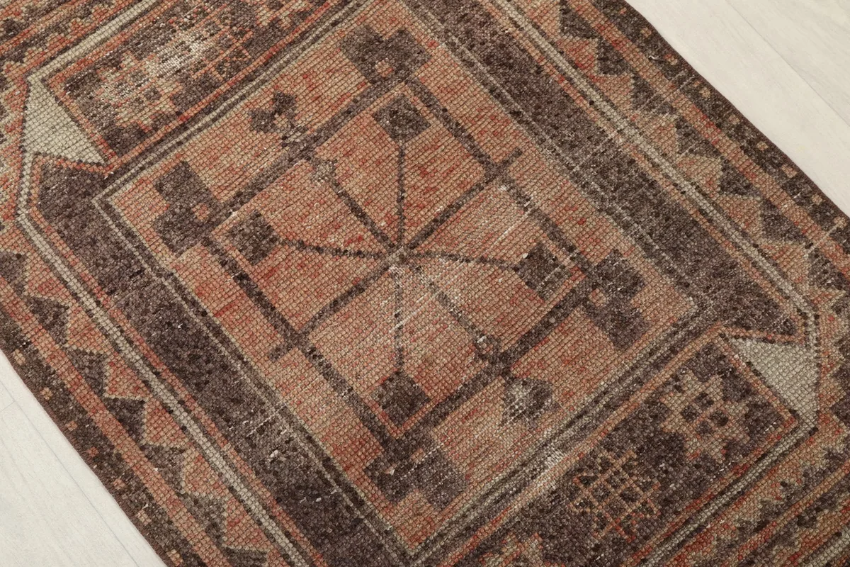Close-up of a central medallion motif with intricate tribal patterns in rust and brown tones