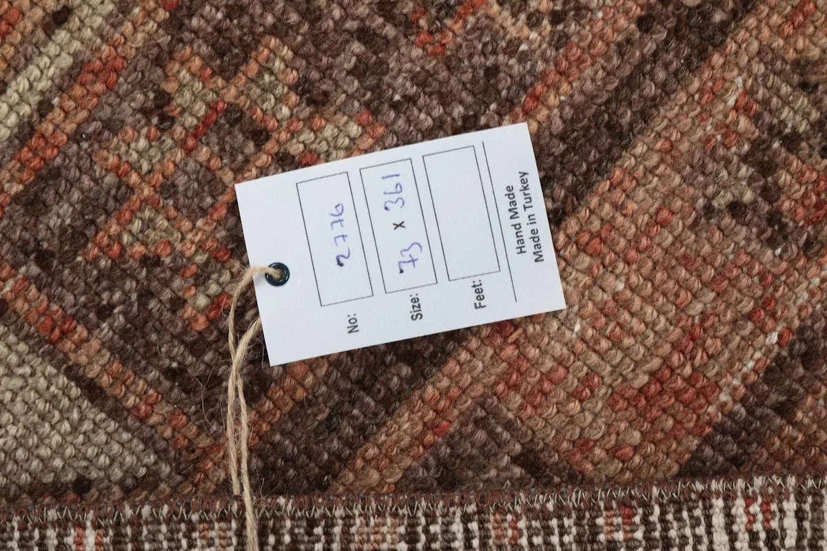 Rug tag displaying the size 73 x 361 cm and indicating hand-made in Turkey
