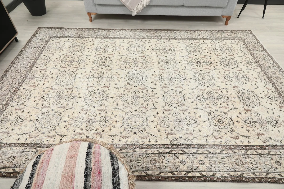 Frontal view of the ivory and brown floral vintage Anatolian rug in a styled room