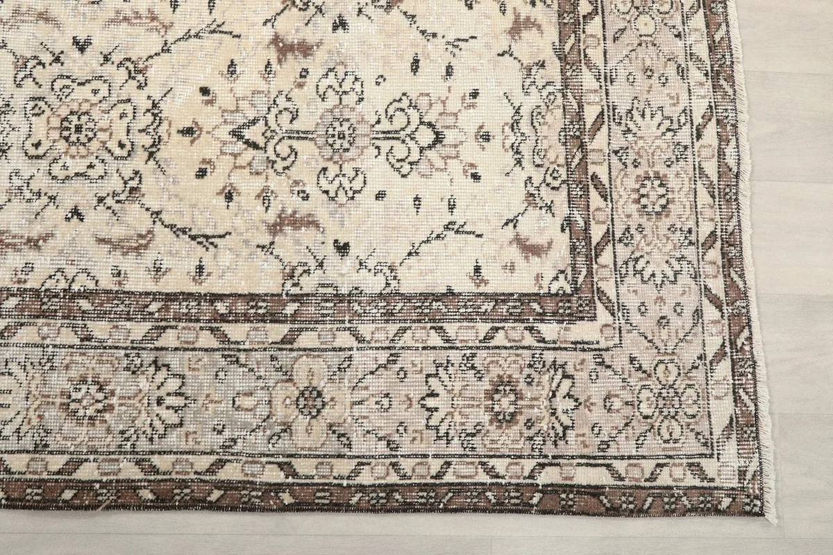 Detail of the brown and beige geometric border and corner of the vintage Anatolian rug