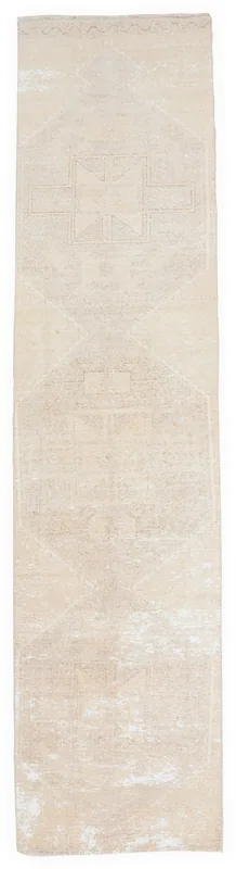 Full overhead view of the beige geometric vintage Anatolian runner rug on a white background.