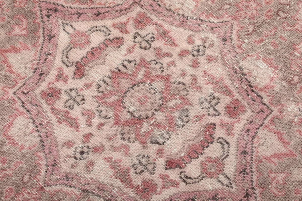 Detailed view of the intricate patterns within the central medallion of the rug