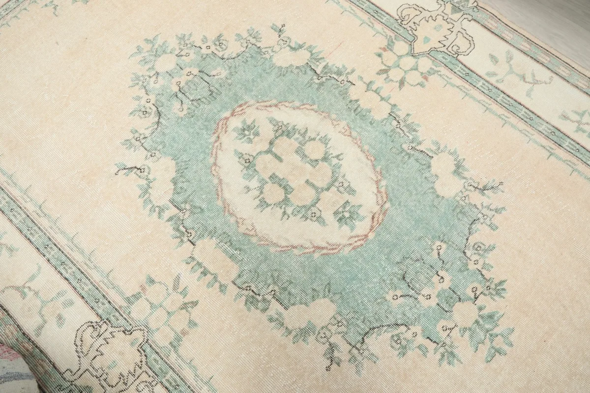 Detailed view of the central green floral medallion on the cream field