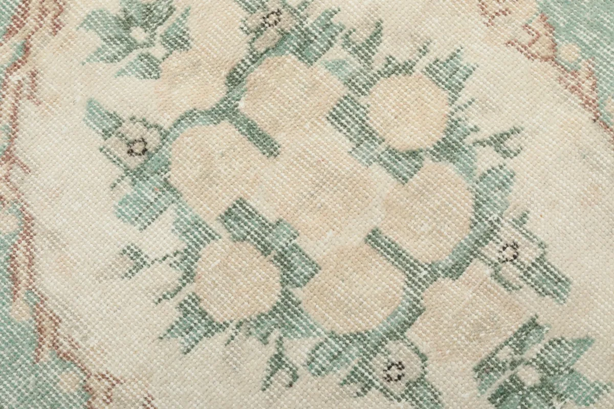 Close-up of the intricate floral patterns within the green medallion