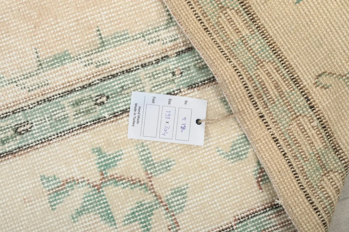 Back of the hand-knotted wool rug with a size tag showing dimensions
