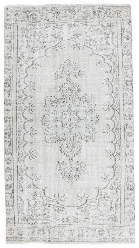 Full top view of the 4'6" x 8'6" ivory vintage Anatolian rug with central medallion and geometric patterns