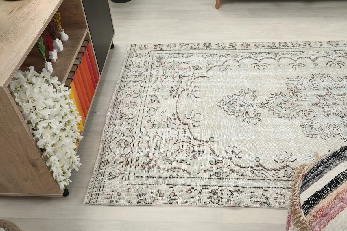 Side angle view of the ivory rug in the room, showing its elongated shape