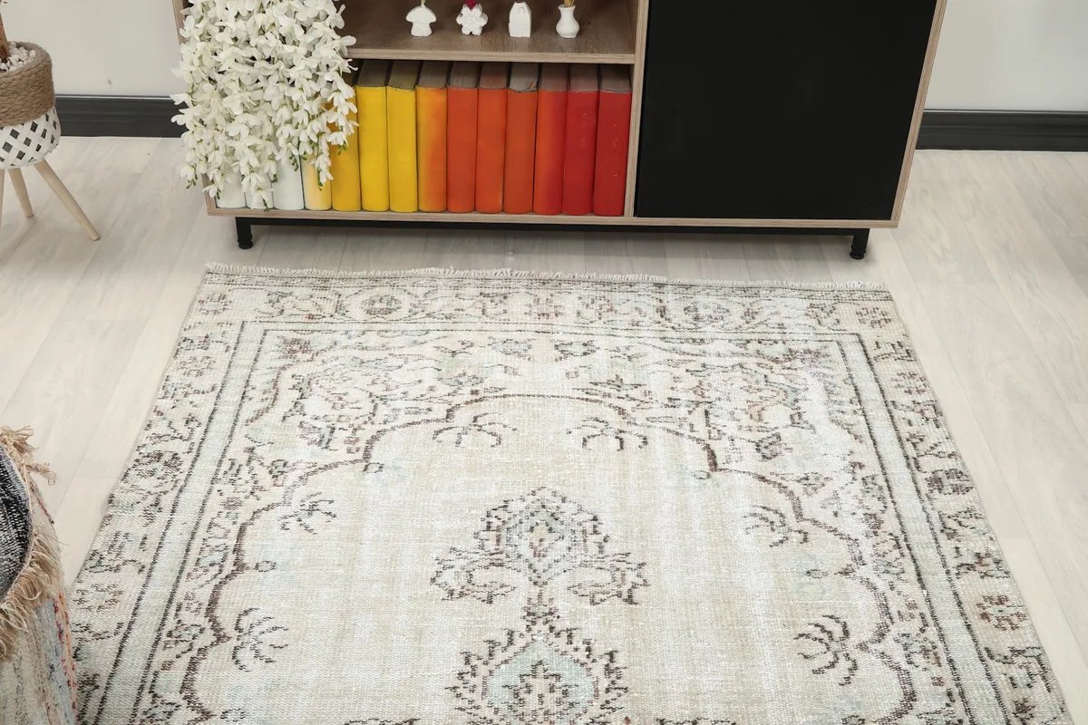View of the ivory vintage rug from a higher angle in the living room, showing its placement